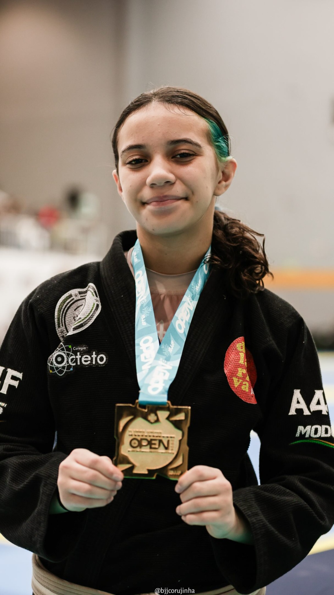 Isa Aguiar de kimono exibindo uma medalha conquistada