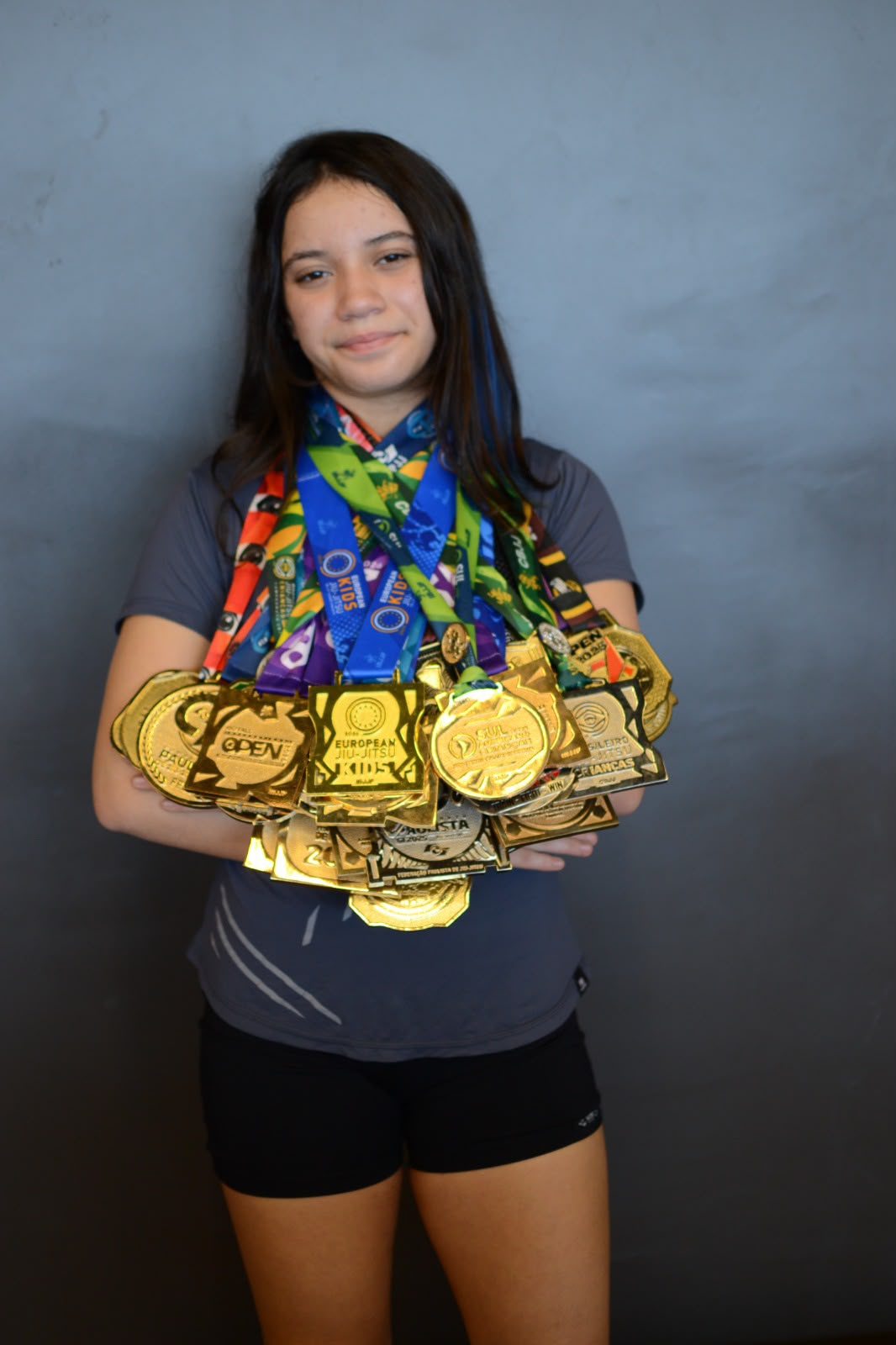 Isa Aguiar exibindo várias medalhas conquistadas no Jiu-Jitsu